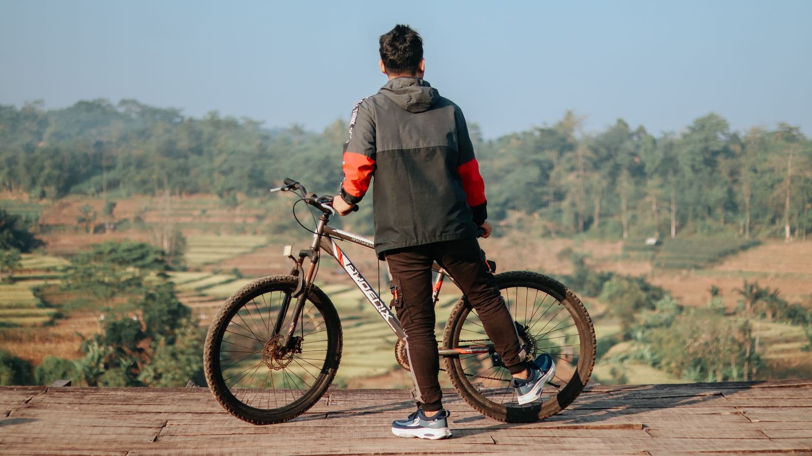 A cyclist looking across green fields