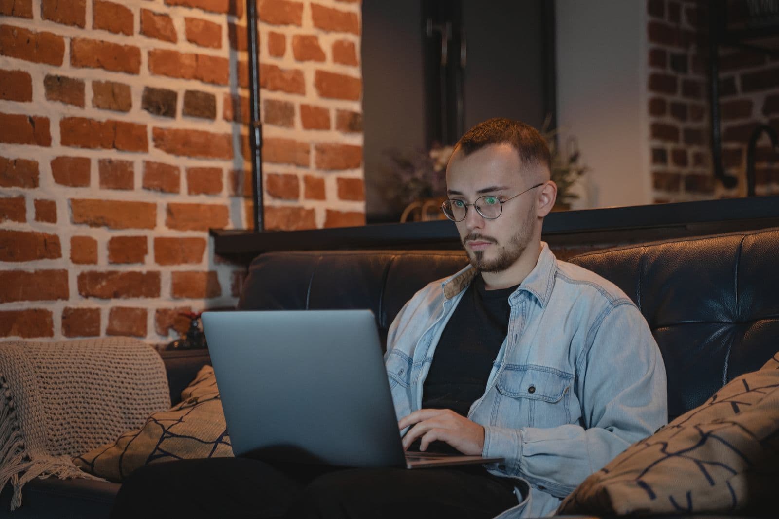 A man using a laptop on a sofa
